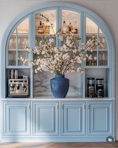 a vase filled with flowers sitting on top of a blue cabinet