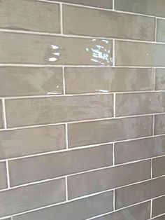 a white toilet sitting next to a gray tiled wall