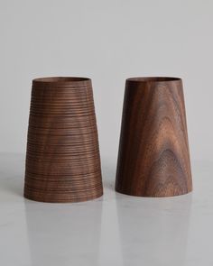 two wooden vases sitting side by side on a table