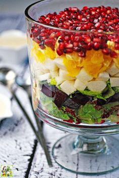 mexican christmas salad in a glass dish with pomegranates and bananas on top