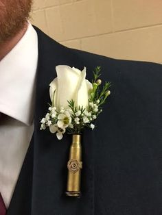 a man wearing a suit and tie with a boutonniere on his lapel