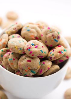 a white bowl filled with cookies covered in sprinkles on top of a table