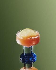 a margarita sitting on top of an orange and blue bottle