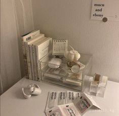 a table with books, cups and teapots on it next to each other