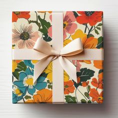 a gift wrapped in floral paper with a bow