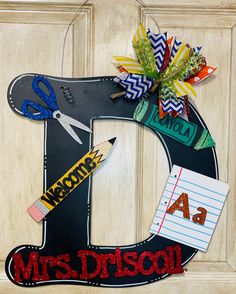 a door hanger with scissors, pencils and paper on it