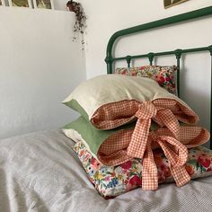 the pillows are piled on top of each other in front of an iron headboard