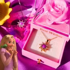 the necklace is in its pink box next to it's flower