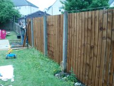 a man standing next to a wooden fence