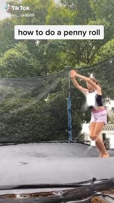 a woman standing on top of a trampoline with her arms in the air