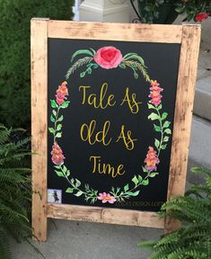 a chalkboard sign that says tales as old as time with flowers and leaves around it