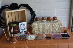 a table topped with lots of desserts and candies next to a wooden crate