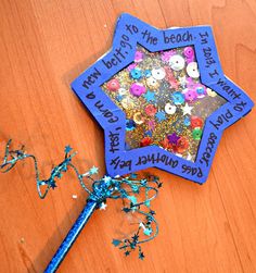 a star shaped brooch sitting on top of a wooden table next to confetti