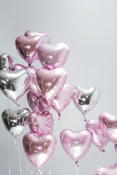 a bunch of heart shaped balloons floating in the air