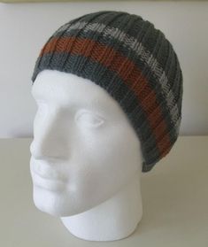 a white mannequin head wearing a gray, orange and black knitted hat