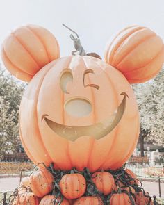 a mickey mouse pumpkin sitting on top of a pile of pumpkins