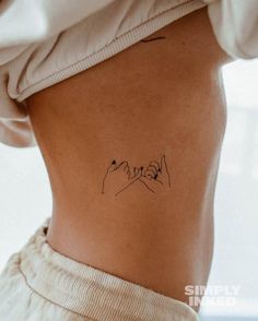 a woman's stomach with a small tattoo on her lower back and right side