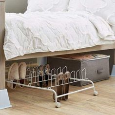 a rack with shoes on it in front of a bed