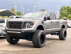 a silver truck parked in a parking lot next to other cars and trucks on display