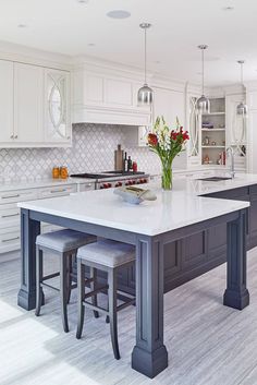 a large kitchen with an island and two stools