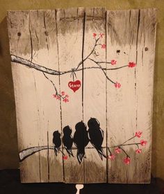 two birds sitting on a tree branch with red flowers painted on the wood planks