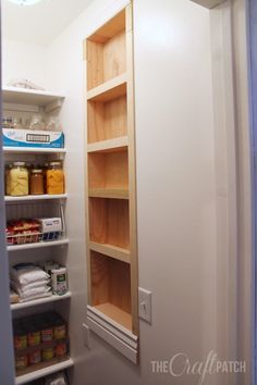 an empty pantry with lots of shelves and food on the shelf in front of it