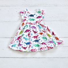 "2-3 WEEK TURNAROUND TIME. This handmade dress is the perfect addition to any little's wardrobe! Great for all year cuteness! Perfect for that little girl, (or mom!) who loves dinosaurs! Dress has 3 sleeve length options: tank, short sleeves, and 3/4 sleeves, with a lined bodice, and full skirt. Skirt is a \"circle skirt\" meaning it has lots of twirl and sing to it, without a ton of bulk to weigh it down. This fabric is white with watercolor painted dinosaurs in rainbow colors! Good mix of pink Cute Multicolor Twirl Dress For Playdate, Fun Green Dress For Playdate, Fun Green Dresses For Playdates, Cute Multicolor Twirl Dress For Play, Playful Multicolor Playwear Dresses, Fitted Multicolor Twirl Dress For Playdates, Fun White Dresses For Birthday, White Twirl Dress For Summer Fun, Cute Multicolor Short Sleeve Twirl Dress