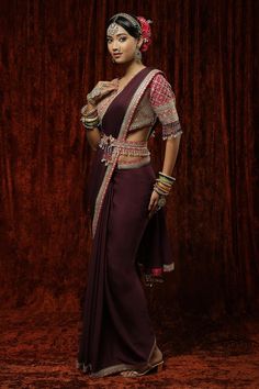 Dark mauve saree with gota, dori embroidered contrast border. Paired with half sleeve rani padded blouse with badla, kasab, crystal drops embroidery and belt.
Components: 3
Pattern: Embroidery
Type Of Work: Gota, Dori, Kasab, Badla
Neckline: V neck
Sleeve Type: Half sleeves
Fabric: Saree: Pure Crepe, Blouse: Silk Chanderi
Color: Purple
Other Details: 
Crystal drops on sleeve hem
Back tassel tie-up
Inverted V hem
Note: All the jewellery worn by the model is not for sale
Occasion: Wedding - Aza Fa Purple Blouse Piece With Dori Work For Reception, Purple Saree With Unstitched Blouse For Reception, Traditional Pre-draped Saree With Mirror Work For Reception, Traditional Purple Blouse Piece For Reception, Traditional Purple Pre-draped Saree For Designer Wear, Purple Traditional Drape Blouse For Reception, Traditional Drape Purple Blouse For Reception, Purple Blouse Piece With Mirror Work In Traditional Drape, Traditional Drape Purple Blouse Piece With Mirror Work