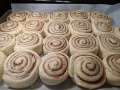 several cinnamon rolls are sitting on a baking sheet and ready to be baked in the oven