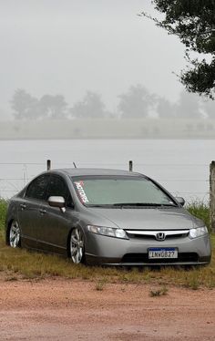 a silver car parked in front of a lake