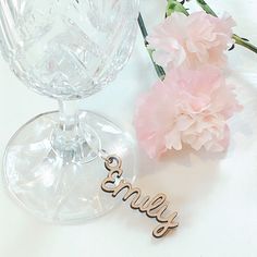 a wine glass with the word enjoy on it next to a pink carnation flower