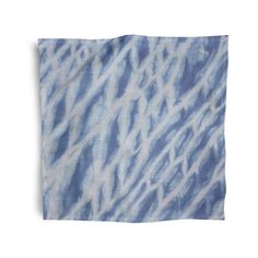 a blue and white tie dyed napkin on a white background with an abstract pattern in the middle