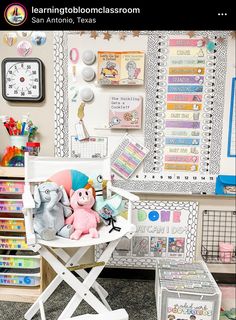 a child's chair with stuffed animals on it in front of a bulletin board