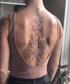 the back of a woman's neck with flowers on it