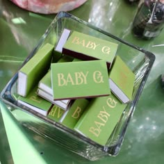 baby g blocks are stacked on top of each other in a square glass container with the word baby g written on them