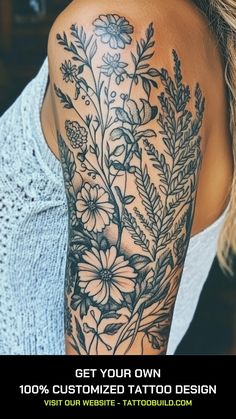 the back of a woman's shoulder with flowers and leaves tattooed on her arm