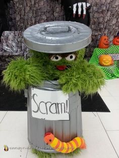 the sesame street character is sitting on top of a trash can with a sign that says scream