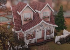 a small doll house with flowers on the windows and balconies in front of it