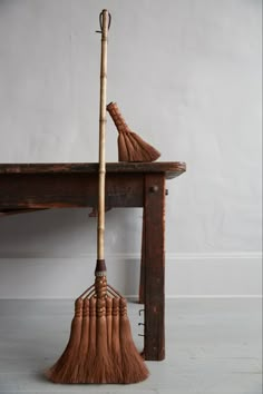 two brooms sitting on top of a wooden table