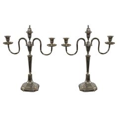 two metal candelabra with candles on each side