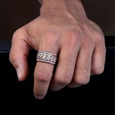 a man's hand with a wedding band on his finger, wearing a diamond ring