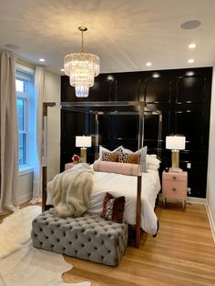 the bedroom is decorated in black and white, with a chandelier above it