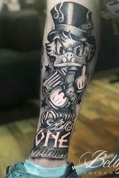 a man's leg with tattoos on it and an image of a cat in top hat