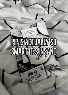 a pile of books sitting on top of a bed covered in white sheets and black stripes