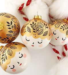 three christmas ornaments with faces painted on them