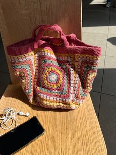 a purse sitting on top of a wooden chair next to a cell phone and wallet