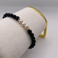 DESCRIPTION: Onyx and Genuine Pearls Bracelet. The sleek, dark onyx contrasts beautifully with the luminous pearls, creating a sophisticated and timeless design. Onyx symbolizes strength and grounding, while pearls represent purity and elegance. Together, they make a stunning bracelet that's both classic and meaningful. FEATURES: Genuine Stones & Pearls. 8mm beads. Filled gold 18k. Pearls Bracelet, 8mm Beads, Pearl Bracelet, Timeless Design, Onyx, Sleek, Bracelet, Beads, Stone