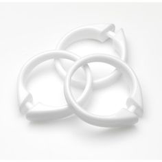 three white plastic rings on a white surface