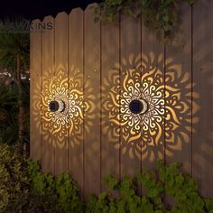 two decorative lights on the side of a wooden fence