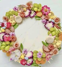 an arrangement of flowers and fruit arranged in the shape of a wreath